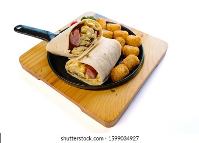 Breakfast burrito with sausage and scrambled egg and vegetable on a wooden plate