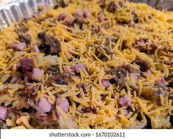 Breakfast Casserole With Eggs, Sausage, Ham, Bacon Bits, Home Fries, And Shredded Cheddar In A Foil Pan For A Tailgate Breakfast Or Large Gathering