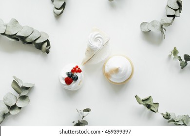 Breakfast composition with cakes and eucalyptus branches on with background. Flat lay, top view Stock Photo