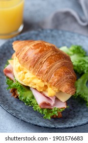 Breakfast Croissant Sandwich With Scrambled Eggs And Ham On A Blue Plate, Closeup View