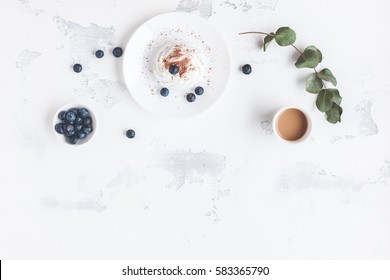 Breakfast with cup of coffee, sweet dessert, blueberry. Flat lay, top view.