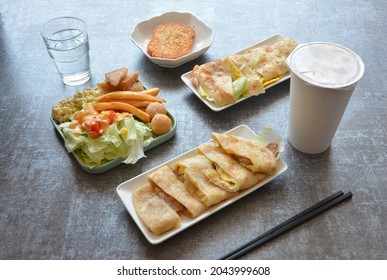 Breakfast Dishes At Chic Taiwanese Breakfast Restaurant Including Hash Brown Patty, Salad, Taiwanese Egg Omelette Or Crape, Water And Soy Milk. Plain Background