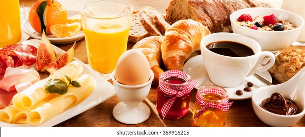 Breakfast Feast With Egg, Meat, Bread, Coffee And Juice