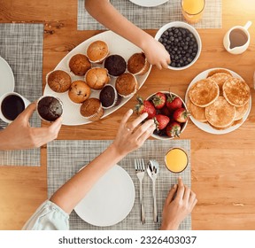 Breakfast, food and hungry people in dining room, eating healthy and above table setting or home in the morning. Fruit, pancakes and hands on strawberry or muffin plate for nutrition or diet - Powered by Shutterstock