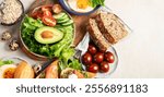 Breakfast food table. Huge healthy breakfast spread on a table with orange juice, fruit, vegetable, muesli, salmon, egg and croissants on a light background. Top view. Panorama with copy space.