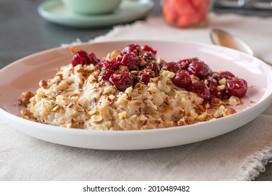 Breakfast With Fresh Cooked Porridge Served With Sour Cherry Compote And Crashed Hazelnuts Topped With Flaxseeds