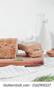 Breakfast with freshly baked sesame bread and milk. Whole grain bread on a wooden board. Gluten free bread. Copy space. - Shutterstock ID 2162905227