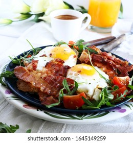 Breakfast With Fried Eggs, Bacon, Fresh Salad, Orange Juice And Coffee On Table. Top View. White Background