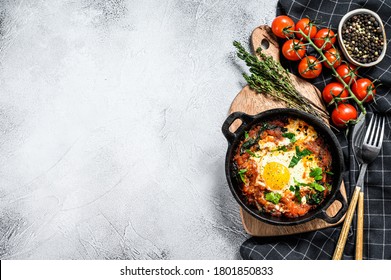 Breakfast with Fried eggs, tomatoes. Shakshuka in pan. Turkish traditional dishes. Gray background. Top view. Copy space