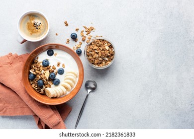 Breakfast granola cereal bowl with yogurt and fruits on grey concrete background. Top view copy space. Terra cotta color concept - Shutterstock ID 2182361833