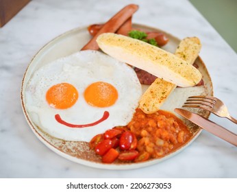 Breakfast. Happy Breakfast with sunny side up fried eggs peppers on top and ketchup smiling at you. Top view food photography. - Shutterstock ID 2206273053