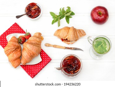 Breakfast with herbal tea, croissants and jam on the white wooden table, top view - Powered by Shutterstock