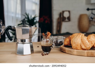 Breakfast at home fresh espresso coffee from the classic Italian geyser coffee maker moka and croissants on the table - Powered by Shutterstock