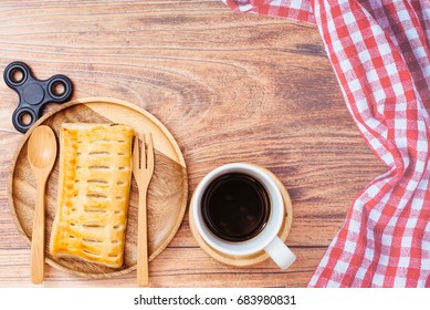 Breakfast, Homemade Pineapple Pastries On Vintage Style Wooden Plate Set And Cup Of Black Coffee On Wooden Background, The Napkin On Right Side And Black Spinner Toy Left Side.