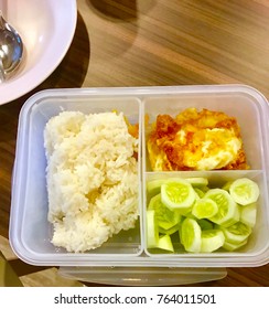 Breakfast includes, rice, cucumber, eggs, in a box of rice.
