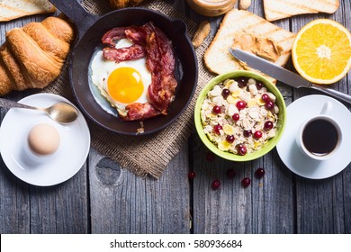 Breakfast including coffee, fried egg , croissant, orange juice , muesli and bread .