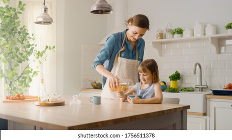 Breakfast in the Kitchen: Young Beautiful Mother Pours Cereal into Bowl, Adorable Little Daughter Starts Eating with Pleasure. Caring Mother Prepares Cereal Breakfast for Her Cute Little Girl - Powered by Shutterstock