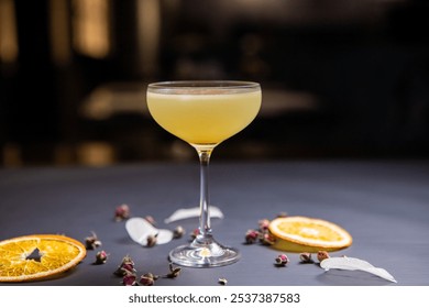 Breakfast Martini cocktail, in a glass on a thin stem, decorated with a dried orange, on a black table decorated with dried oranges - Powered by Shutterstock