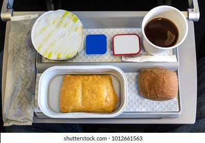 A Breakfast Meal With Coffee, Butter, Bread And Yogurt On A Tray, Onboard A Short Flight In Europe In Economy Class.