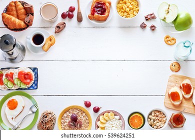 Breakfast menu food frame with a copy space. Eggs, croissants, oatmeal with banana, cereal, danish pastry, crisps with salmon, apricot jam, fresh bread, chocolate, coffee and milk on a white table. - Powered by Shutterstock