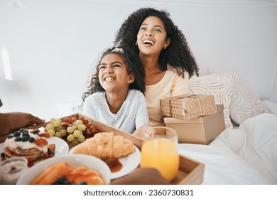 Breakfast, mothers day and child with mom in bed to relax for eating healthy, nutrition and diet. Happy, smile and young woman with girl kid in bedroom with gifts, presents and food at family home. - Powered by Shutterstock