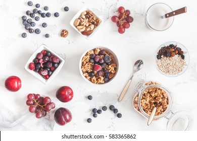 Breakfast with muesli, fruits, yogurt, frozen berries, nuts on white background. Healthy food concept. Flat lay, top view - Powered by Shutterstock