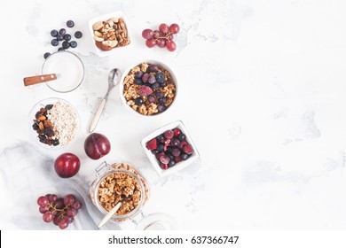 Breakfast With Muesli, Fruits, Yogurt, Frozen Berries, Nuts On White Background. Healthy Food Concept. Flat Lay, Top View