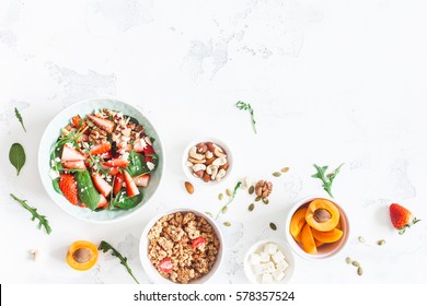 Breakfast With Muesli, Strawberry Salad, Fresh Fruit, Nuts On White Background. Healthy Food Concept. Flat Lay, Top View.