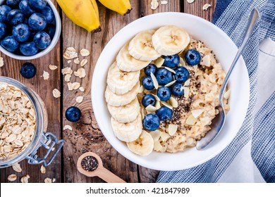 Breakfast: oatmeal with bananas, blueberries, chia seeds and almonds. Top view - Shutterstock ID 421847989