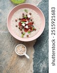 Breakfast oatmeal with fresh fig fruits on a beige and grey granite background, vertical shot, above view