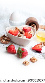 Breakfast With Oatmeal With Strawberries, Honey, Walnuts And Egg On White Background. Breakfast For Child. Oatmeal In A White Heart-shaped Bowl