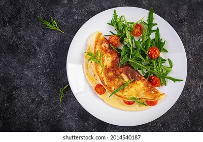 Breakfast. Omelette with tomatoes, cheese  and salad on white plate.  Frittata - italian omelet. Top view
