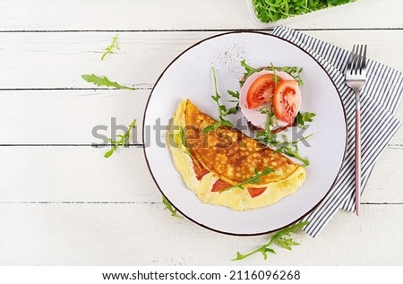 Breakfast. Omelette with tomatoes, cheese and sandwich with boiled sausage.  Frittata - italian omelet. Top view, overhead Stockfoto © 