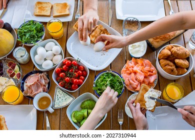 Breakfast On The Terrace Top View. Family Eating Breakfast At The Table Top View.Fried Eggs In A Skillet On A Large Table Filled With Food.Fried Eggs In A Skillet For Breakfast For A Large Family.Lots