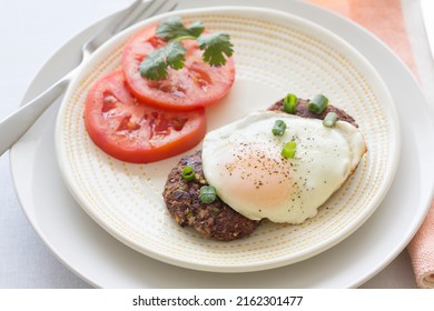 Breakfast For One Mexican Style Black Bean Cakes With Fried Eggs And Sliced Tomatoes