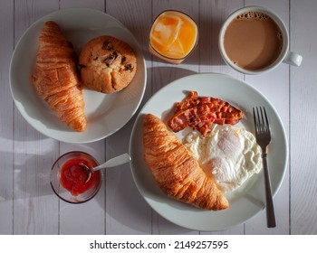 Breakfast With Overmedium Eggs, Bacon , Bread Orange Juice And Cream Coffee On A White Table, Top View Or Overhead Shot