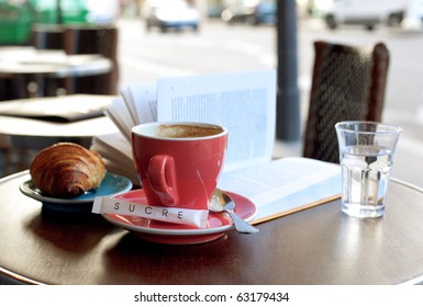 Breakfast in a Parisian street cafe - cup of coffee, croissant and book - Powered by Shutterstock