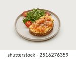 Breakfast plate featuring a slice of whole-grain toast topped with scrambled eggs, smoked salmon, and sesame seeds. A fresh side salad of cherry tomatoes and greens adds a vibrant touch.