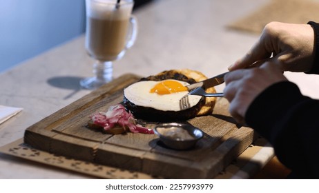 Breakfast with scrambled eggs, a knife and fork cut fried eggs for eating protein and healthy fats for breakfast