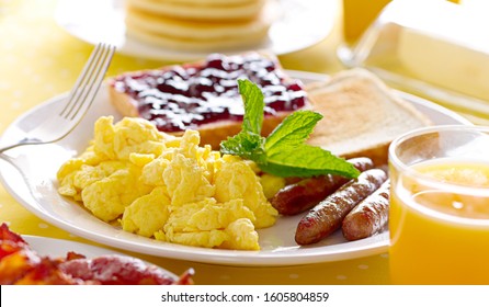 Breakfast With Scrambled Eggs, Sausage Links And Toast.