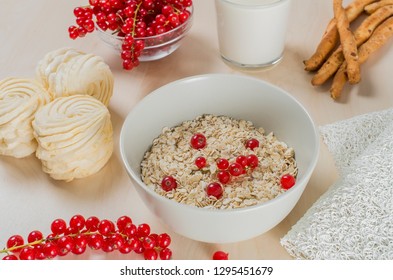 Breakfast Served With Oatmeal, A Glass Of Milk, Bread Sticks, Cranberry And Marshmallow On A Wooden Background. 