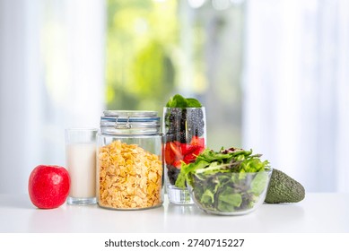 Breakfast served on table kitchen. Fresh muesli with yogurt, fruit, and berries. Granola with milk and honey. Oatmeal with juicy berries.
