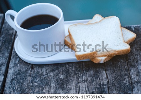 Breakfast set on wooden floor in the morning. Breakfast with coffee and bread.Do not focus on objects.