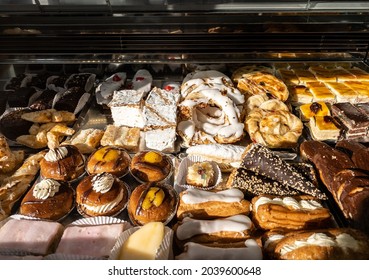 Breakfast of spanish biscuits, sweet pastries, puff pastry, powdered sugar and baked apples dessert. Typical sweets confections consumed in the window of a pastry shop at Spain.