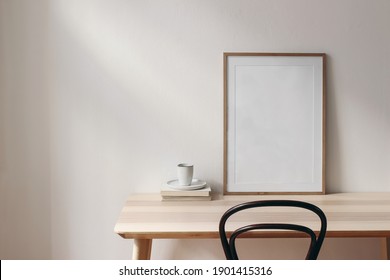 Breakfast Still Life Scene. Cup Of Coffee, Books And Empty Picture Frame Mockup On Wooden Desk, Table. Elegant Working Space, Home Office Concept. Scandinavian Interior Design. Room In Sunlight.