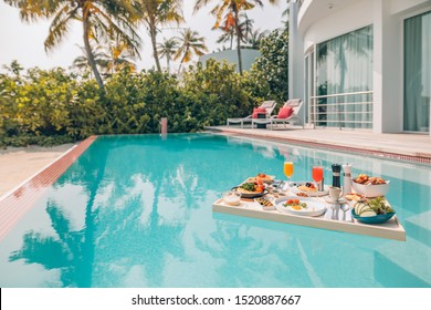 Breakfast In Swimming Pool, Floating Breakfast In Luxurious Tropical Resort. Table Relaxing On Calm Pool Water, Healthy Breakfast And Fruit Plate By Resort Pool. Tropical Beach Luxury Lifestyle
