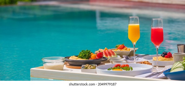 Breakfast In Swimming Pool, Floating Breakfast In Luxurious Tropical Resort. Table Relaxing On Calm Pool Water, Healthy Breakfast And Fruit Plate By Resort Pool. Tropical Couple Beach Luxury Lifestyle