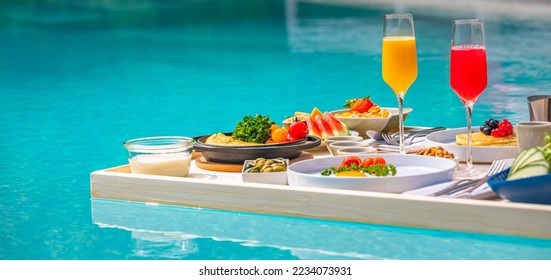 Breakfast in swimming pool, floating breakfast in luxurious tropical resort. Table relaxing on calm pool water, healthy breakfast and fruit plate by resort pool. Tropical couple beach luxury lifestyle - Powered by Shutterstock