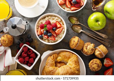 Breakfast Table With Oatmeal Porridge, Croissants, Fresh Fruit And Muffins Overhead Shot