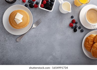 Breakfast Table Overhead With Copyspace, Pancakes And Croissants With Fresh Berries And Coffee